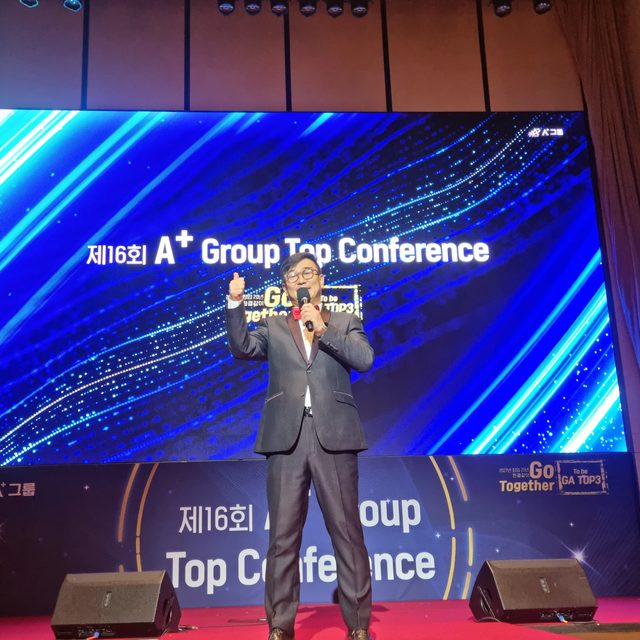 전국 기업 행사 MC 신용주가 대형 스크린 앞 무대에서 마이크를 들고 진행하는 모습