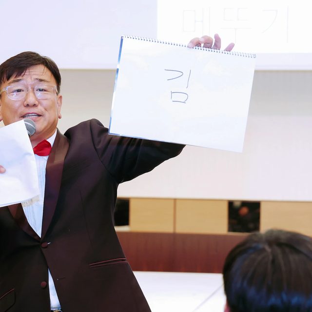 전국 송년회 퀴즈 코너에서 정답 카드를 들어 보이는 MC 신용주
