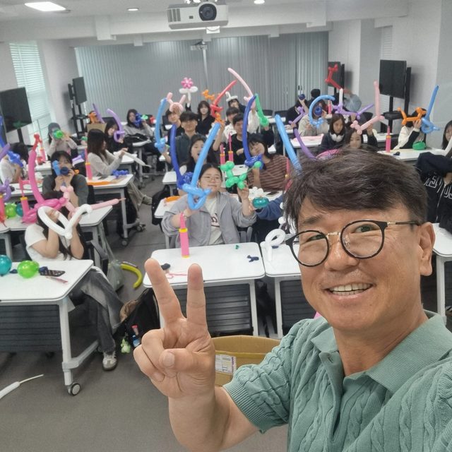 전국 임직원 레크리에이션에서 풍선 소품을 들고 즐거워하는 참석자들과 MC